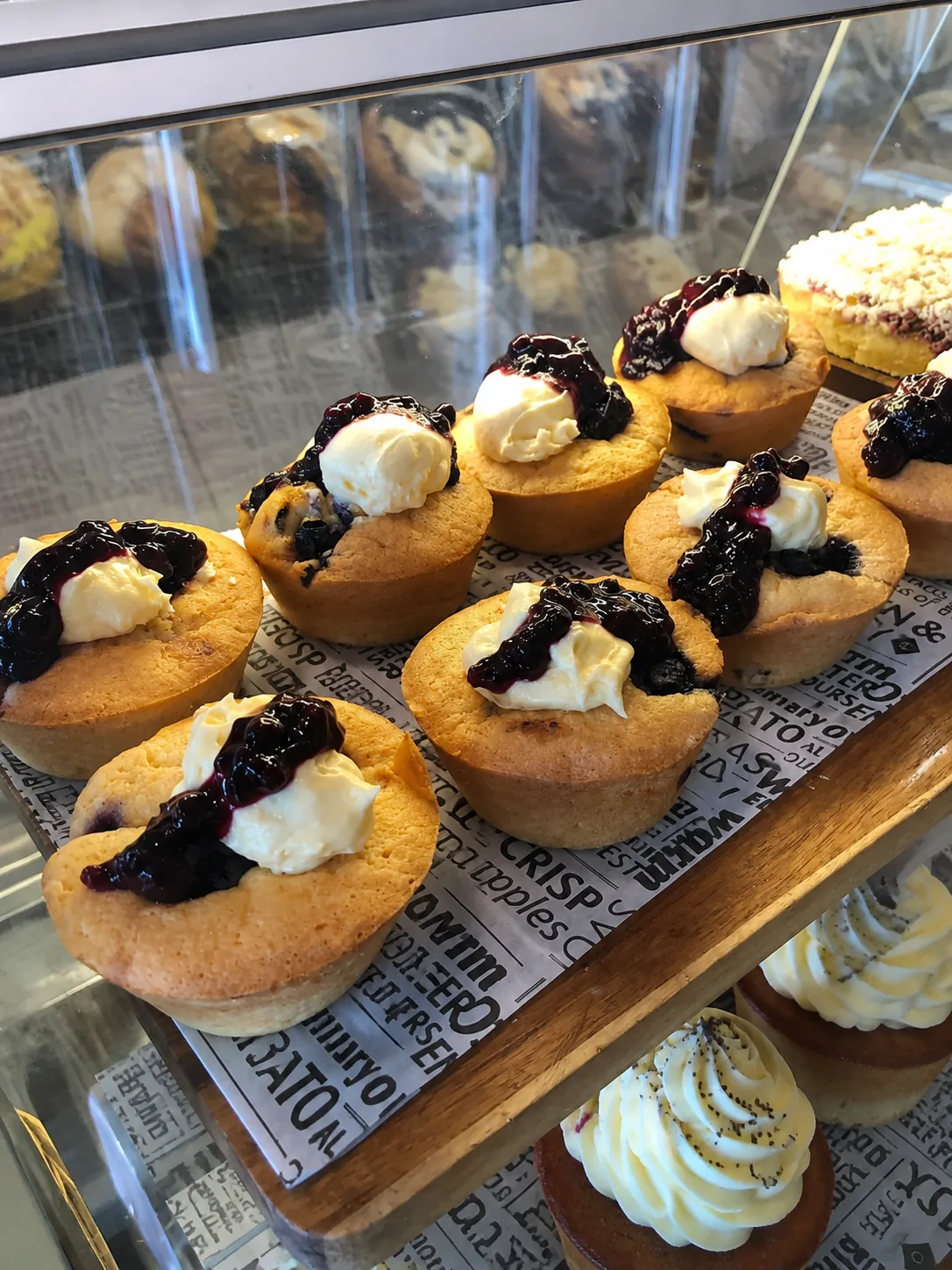 Muffins topped with cream and berry compote in the Grindz Cafe cabinet